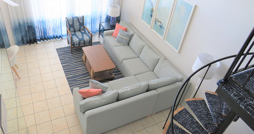 Veranda Beach Club of Longboat, penthouse living room with sectional sofa, spiral staircase, and a view of the Gulf of Mexico
